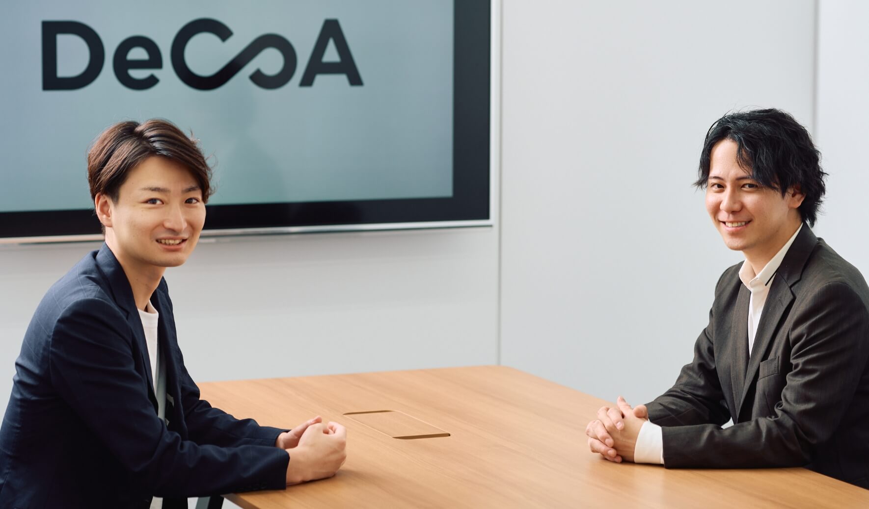 大野と久保が向かい合わせで座っておりこちらを向いている写真