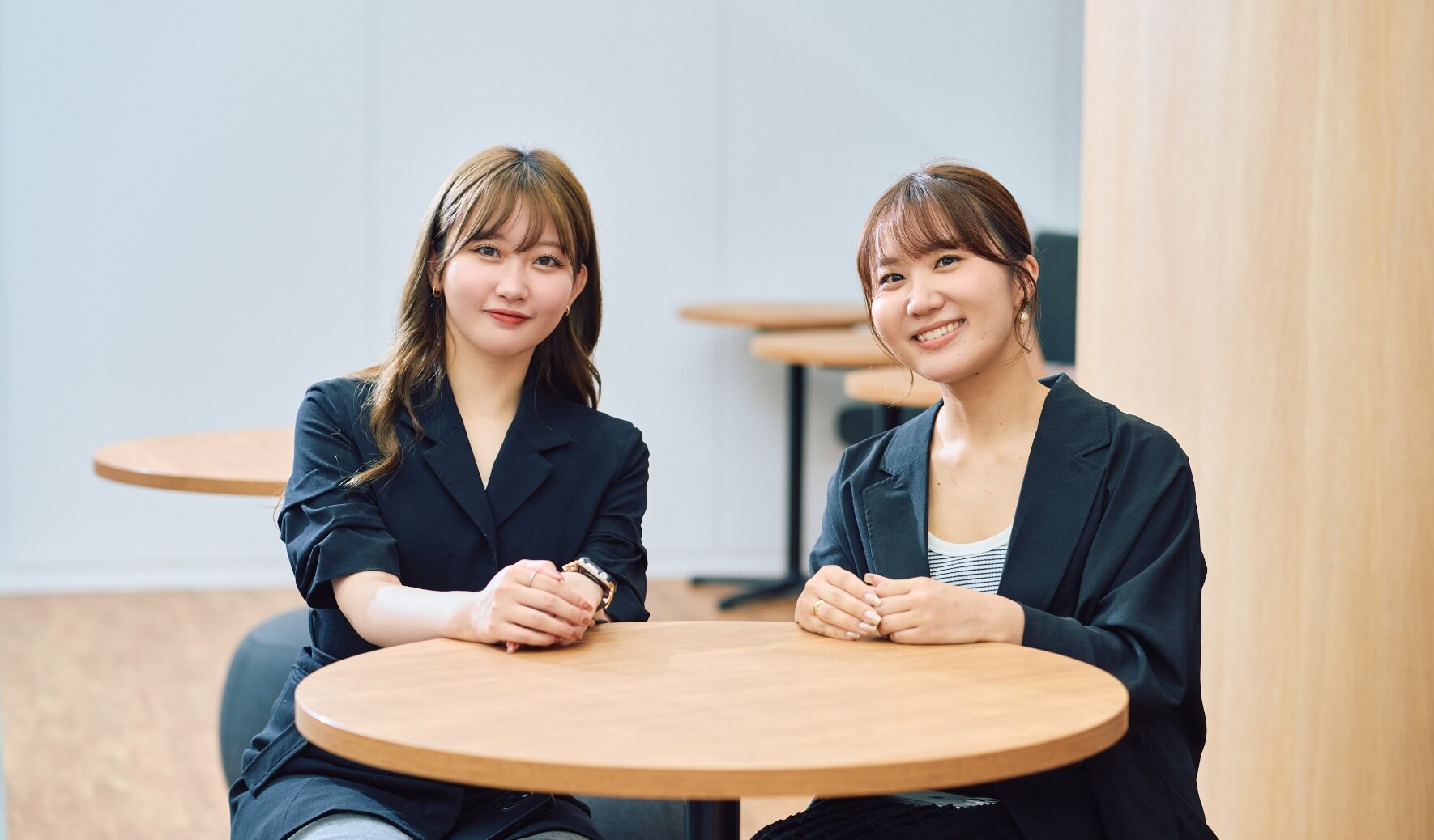 高橋と川崎が横並びで座ってこちらを向いている写真